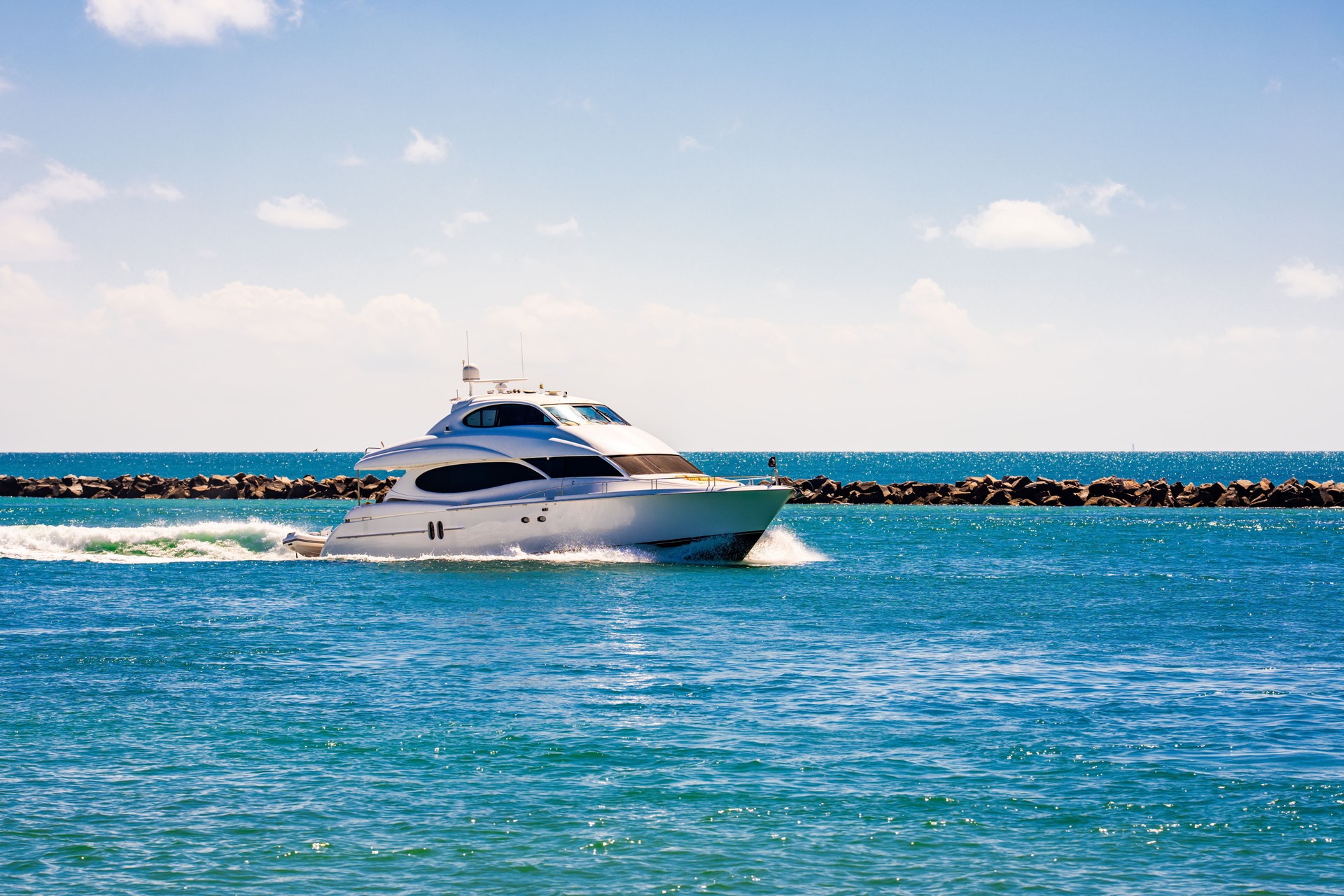 Yacht sailing on sea waters. Luxury superyacht at sea. Miami Beach with yachts. Seascape with a sailboat. Cruise ship near the coastline. Sunset yacht voyage in Florida. Luxury sailboat yacht.